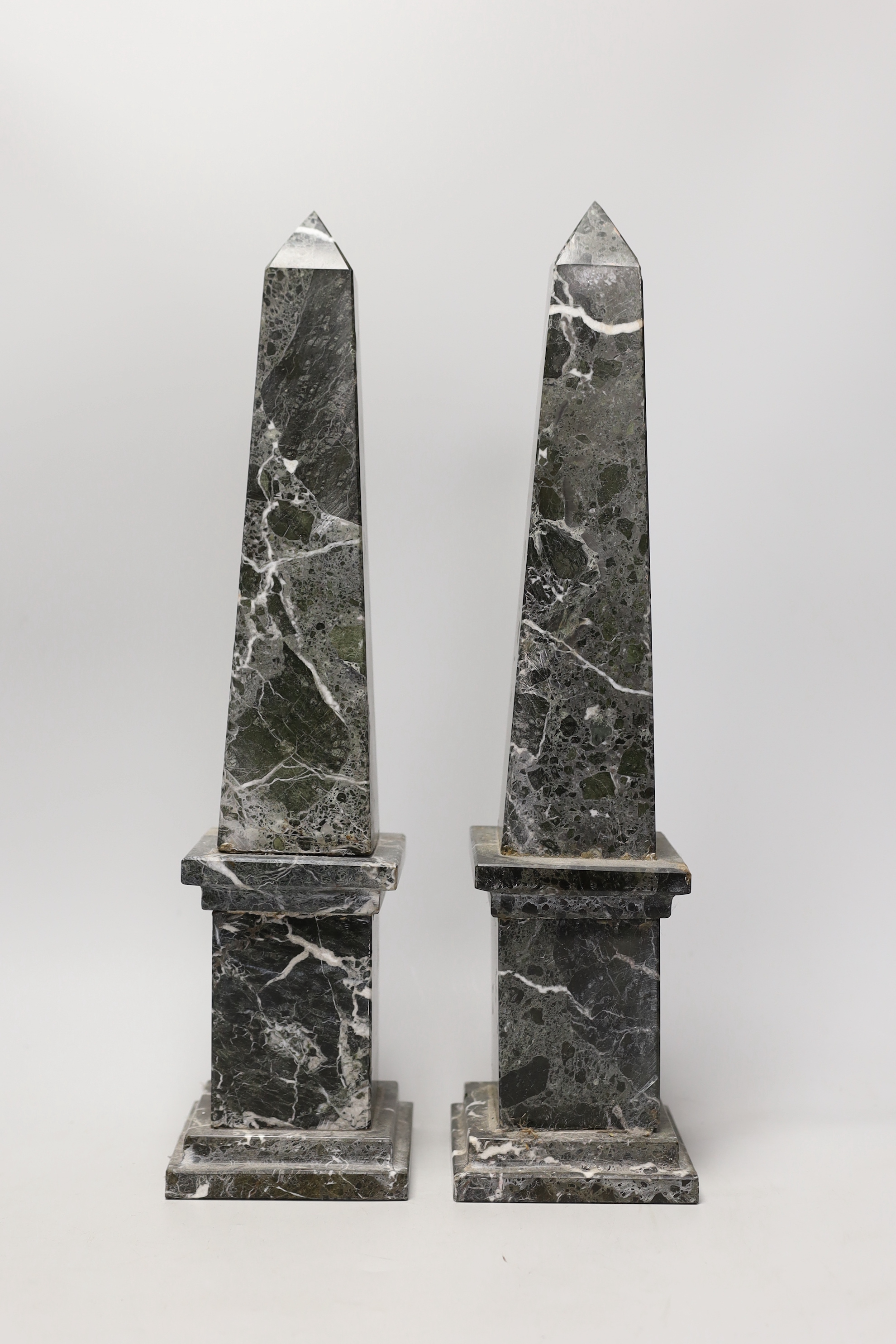 A pair of black and white variegated marble obelisks, 48cm